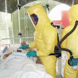Patient in isolation with Ebola virus being cared for by nurses in protective gear Patient in isolation with Ebola virus being cared for by nurses in protective gear
